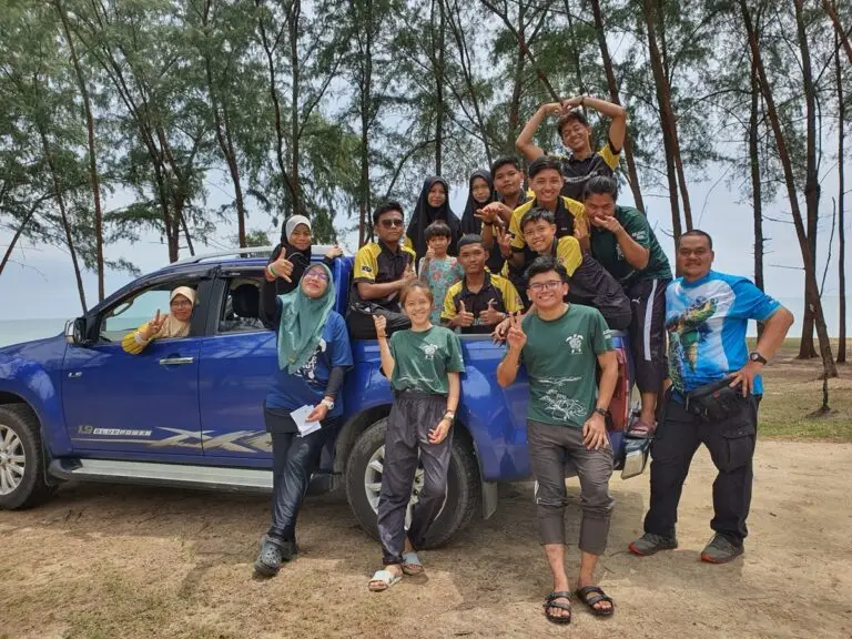 Photograph of volunteers posing in front of a blue truck